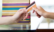 a shopper hands over a credit card