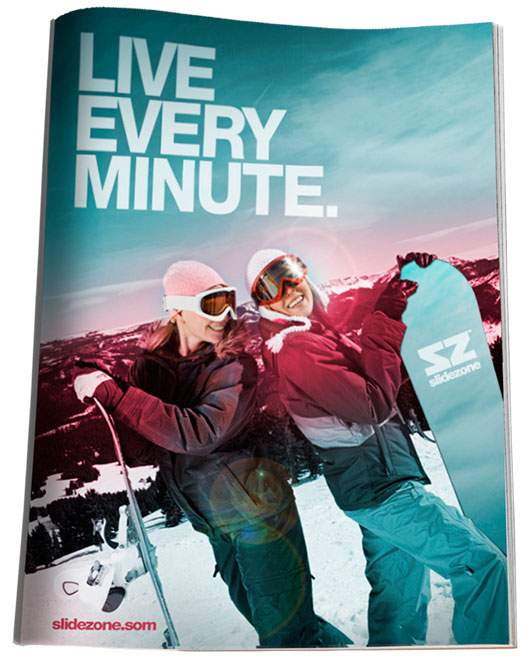 Image of a magazine ad showing two girls on a sunny, snowy mountainside with their faces toward the sun and their boards resting at their sides. 