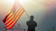 Military person waving an American flag